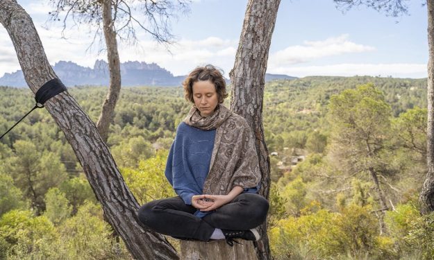 chica meditando en la montaña