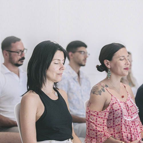 grupo de gente en clase con los ojos cerrados